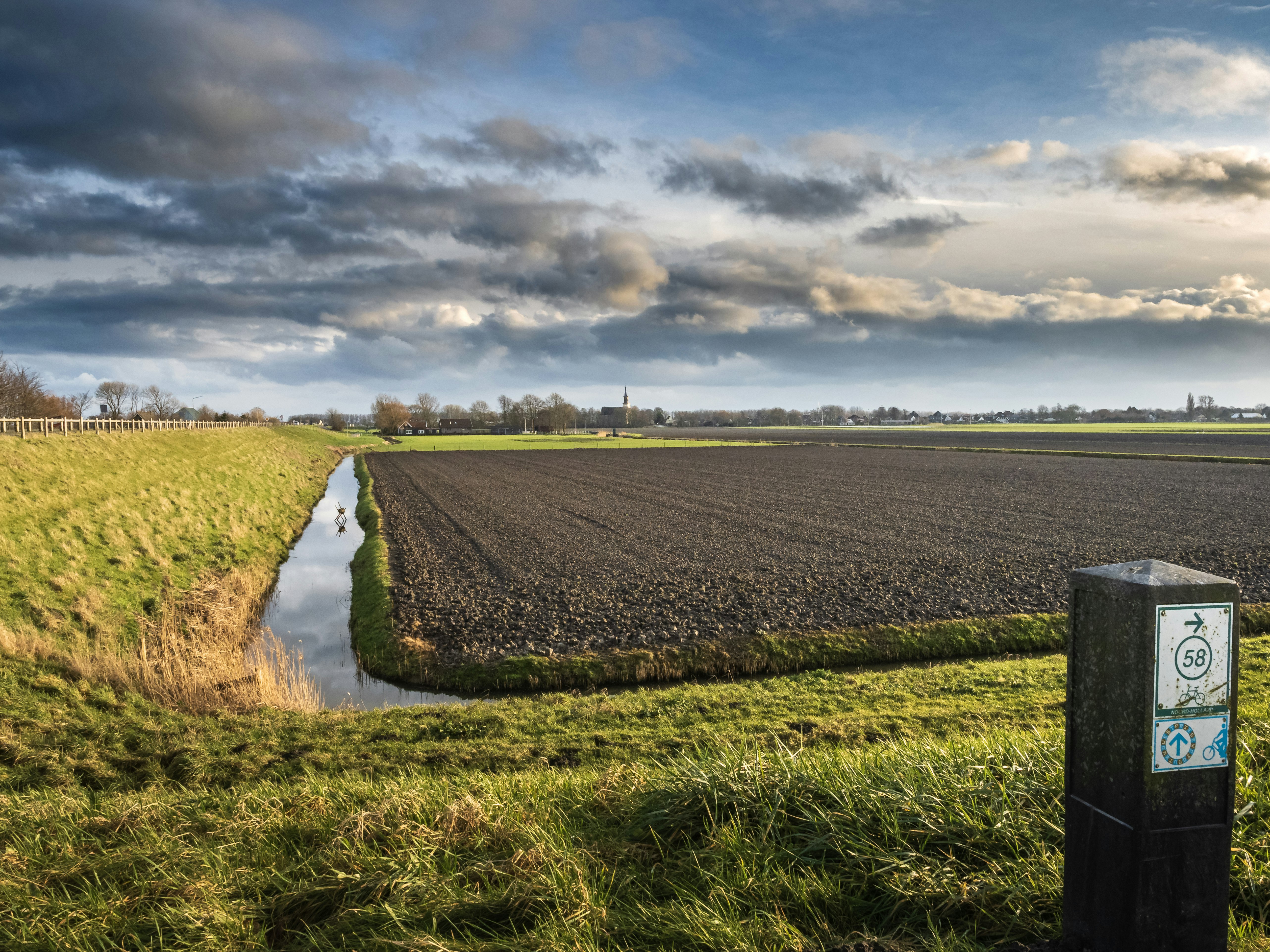 green grass field under cloudy sky during daytime